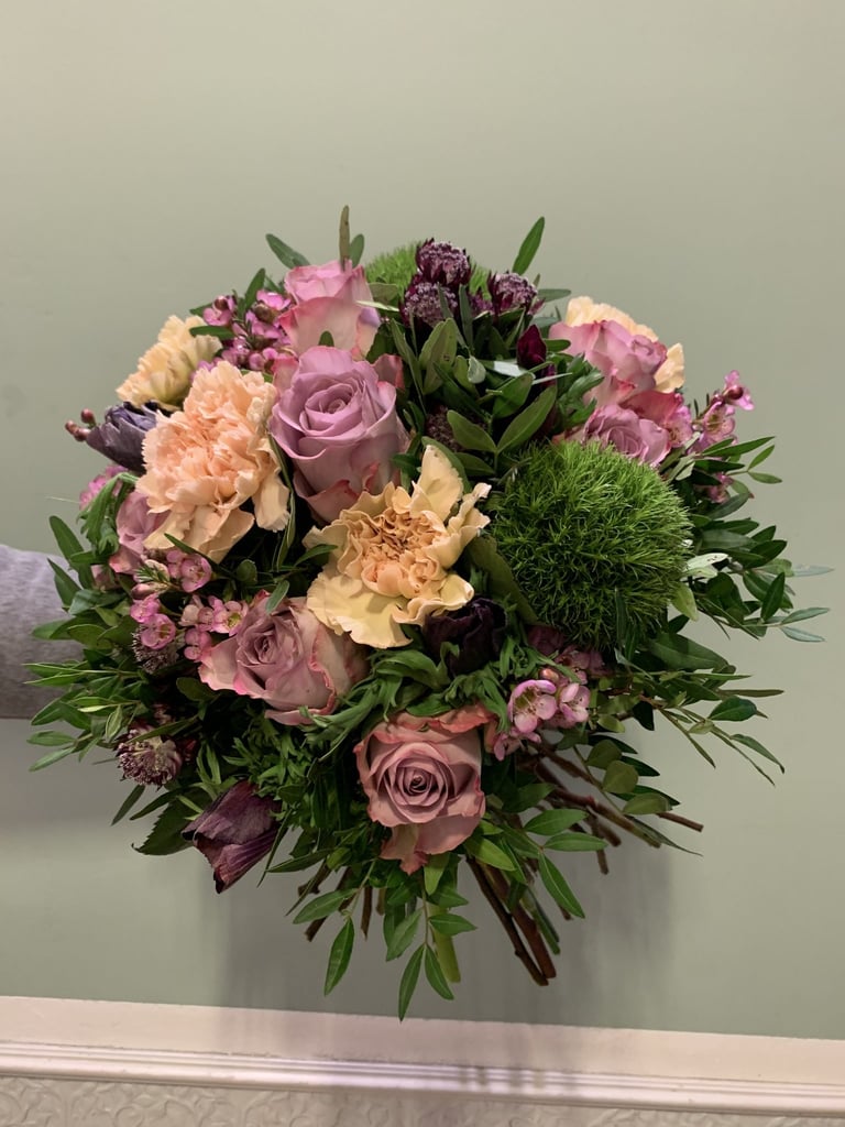 Üppiger Blumenstrauß mit rosa Rosen, pfirsichfarbenen Nelken und lila Blüten